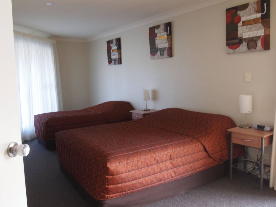 Une chambre d’hôtel avec deux lits, un bureau et une table de chevet.