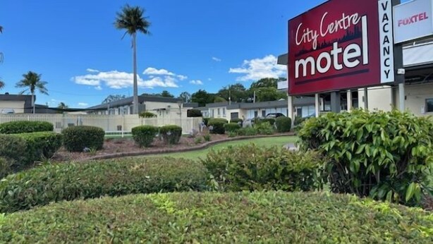 A City Centre motel with a large sign, surrounded by well-maintained landscaping and palm trees. - City Centre Motel (Kempsey)