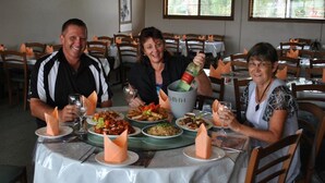 A dining table with multiple plates of food, glasses of wine, and a bottle of champagne. - City Centre Motel (Kempsey)
