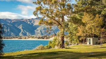 Eine Küstenlandschaft mit einer kleinen Hütte am Wasser, umgeben von Bergen.