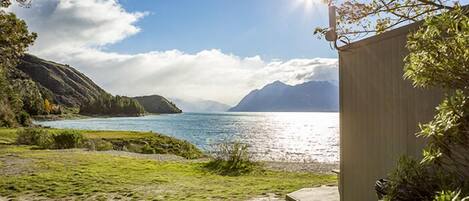A coastal landscape with a clear sky, a body of water, and a wooden structure.