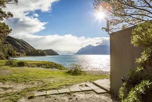 Paisagem costeira com céu claro, um corpo d'água e uma estrutura de madeira.