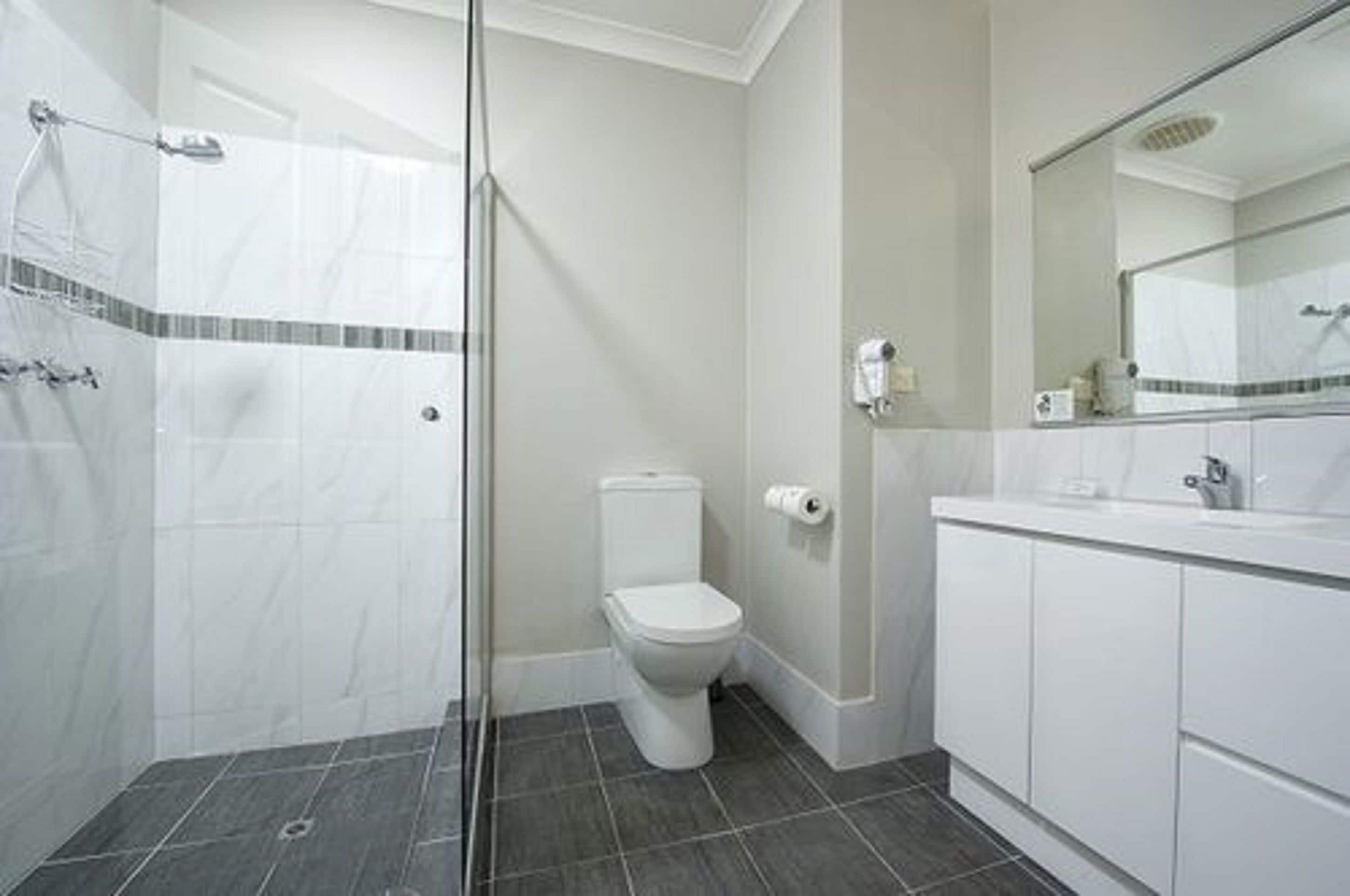 Ein Badezimmer mit Dusche, Toilette und Waschbecken.