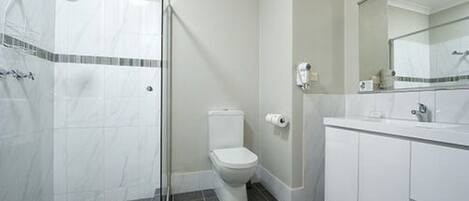Ein Badezimmer mit Dusche, Toilette und Waschbecken.