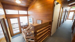 A wooden interior with a staircase leading to a balcony.