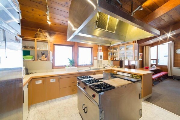 Una cocina moderna con armarios de madera, una isla central con estufa y un amplio ventanal que proporciona luz natural.