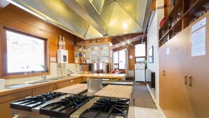 A modern kitchen with a gas stove, wooden cabinets, and a window providing natural light.