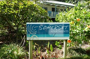 A sign for Somerset Apartments with a leafy design. - Somerset Apartments Lord Howe Island (Lord Howe Island)