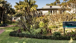 A sign for 'Somerset Apartments' with a garden path and tropical vegetation.
