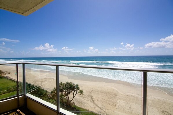 Un balcon avec vue sur une plage et l’océan.