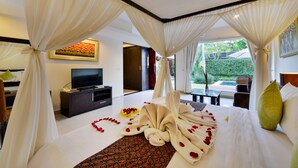 A hotel room with a bed, a television, and a view of the outdoors. - The Yubi Boutique Villas Seminyak (Seminyak)