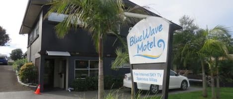 A motel sign with amenities including free internet, SKY TV, and spacious villas.