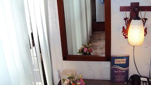 Ein Hotel-Empfangsbereich mit einem Spiegel, der eine Treppe, eine Blumenkomposition und ein Schild mit der Aufschrift 'Room Free Rent' reflektiert.