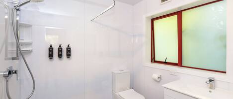 Un baño moderno con ducha, inodoro y lavamanos.