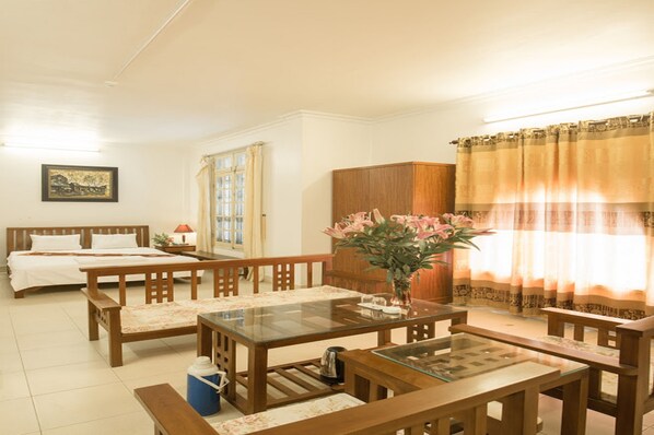A hotel room with a wooden bed, a glass-top dining table, a wooden cabinet, and a window with curtains. - Trang An Plaza Hotel (Hanoi)