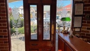 Un área de recepción con puerta de madera, mostrador de recepción y vistas al exterior.