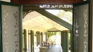 An open doorway leading to a covered porch with outdoor furniture. - Lochinvar House B&B (Lochinvar)