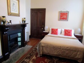 A bedroom with a large bed, a fireplace, and a door. - Lochinvar House B&B (Lochinvar)
