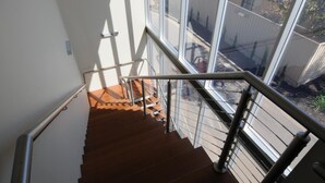 A staircase with metal railings and wooden steps leading to an outdoor area with a view of a building and trees. - The Mansfield Park Hotel (Mansfield Park)
