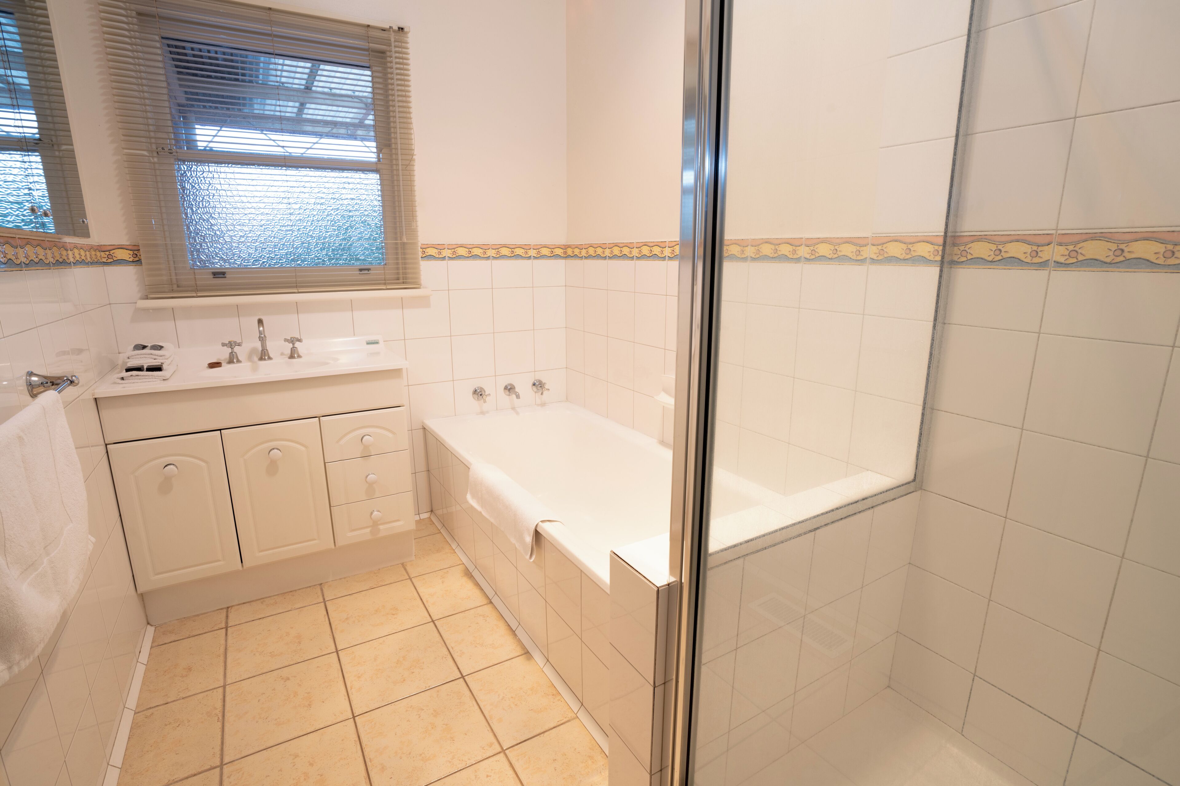 Un baño con bañera, ducha y tocador con espejo.