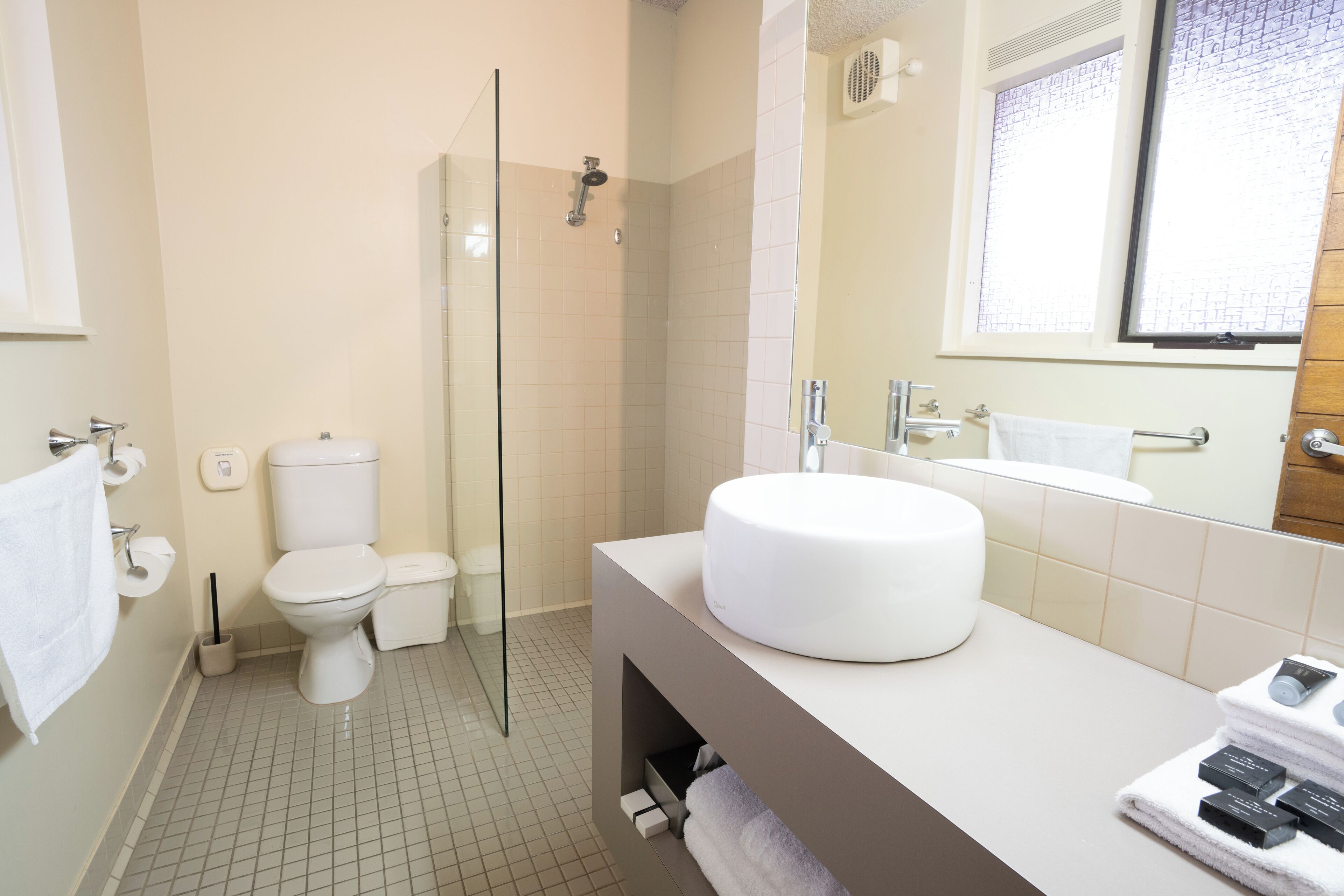 Un baño moderno con inodoro, ducha y lavamanos.