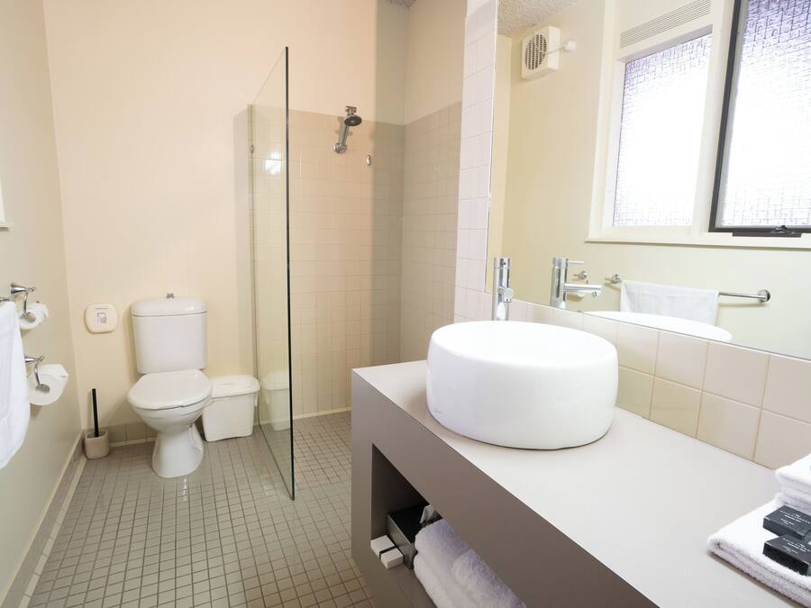 Un baño moderno con inodoro, ducha y lavamanos.