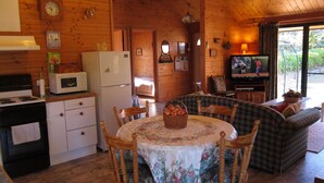 Interior acogedor de una cabaña con comedor, cocina y sala de estar.