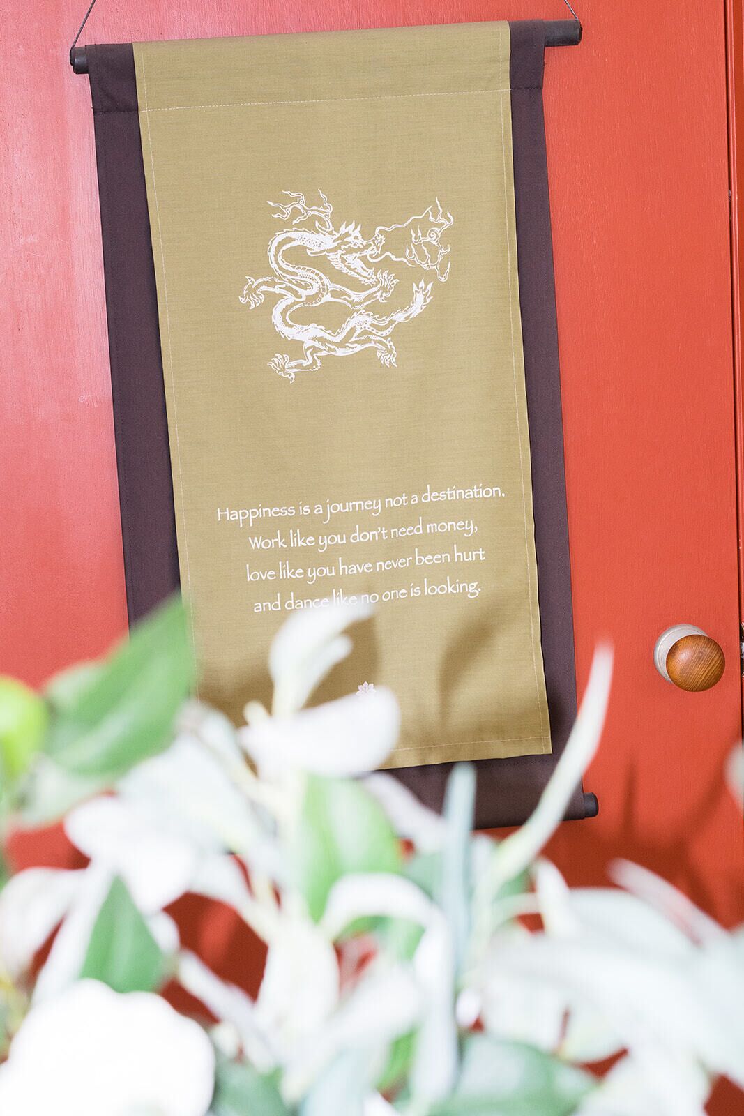 Un rollo con diseño de dragón y texto inspirador sobre una puerta roja.