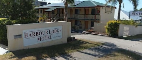 Señal del Motel Harbour Lodge, con un edificio de dos pisos y un balcón.