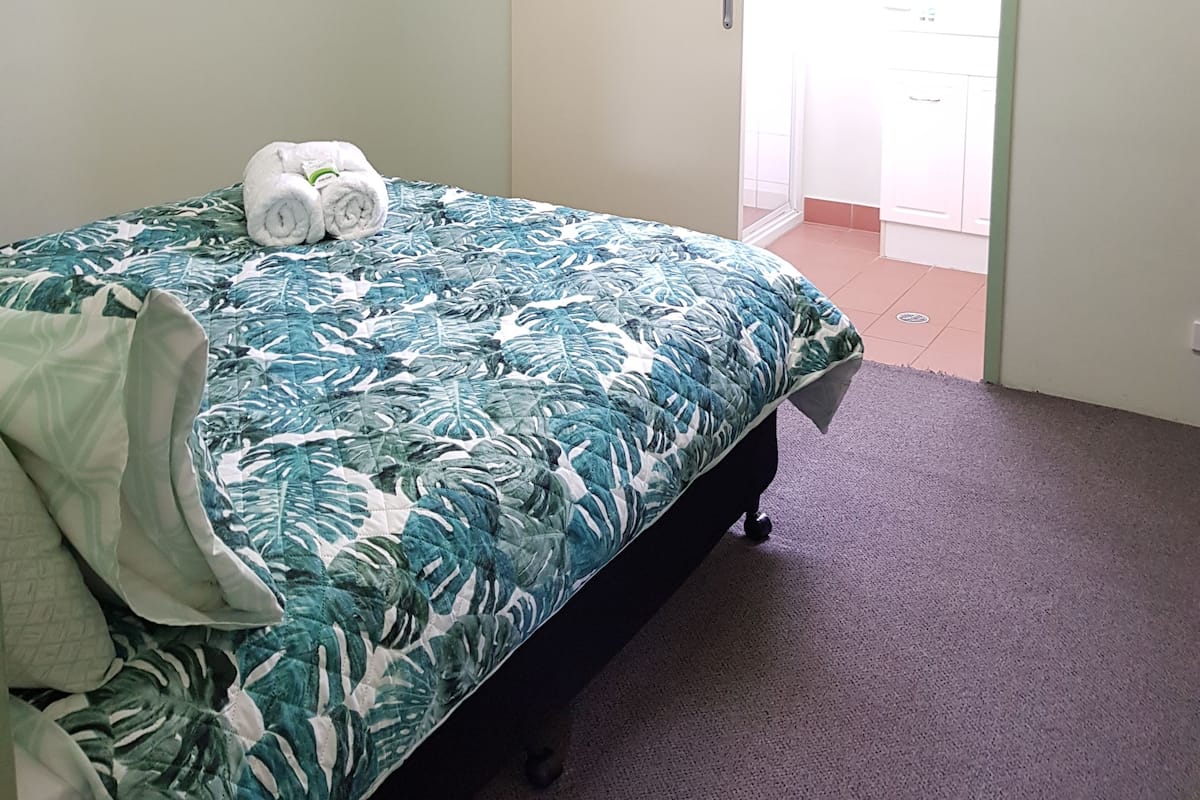 Une chambre à coucher avec un lit, une porte et un couloir menant à la salle de bain.