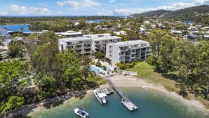 Oversigtsbillede af et resort med flere bygninger, en anløbsbro og både.