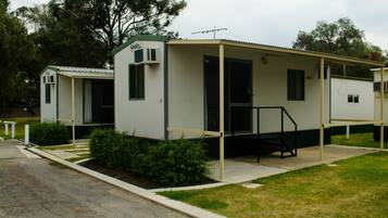 Mobile homes with covered porches and a well-manicured lawn.