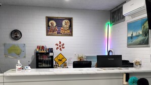 A reception desk with a clock, framed artwork, a map, and a sign indicating internet access. - Wangaratta Motor Inn (Wangaratta)