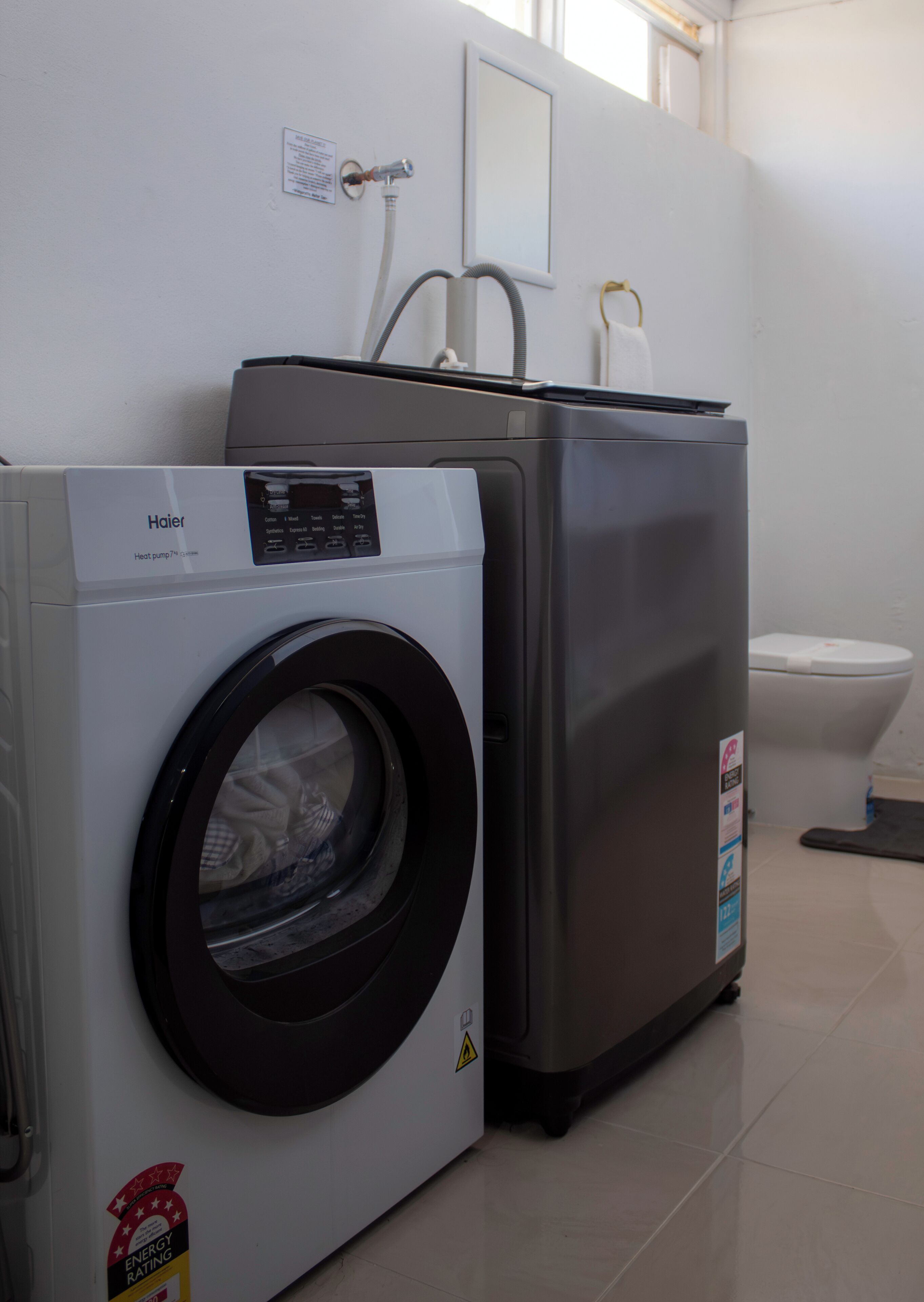 A compact laundry area with a front-loading washer and a stacked dryer.