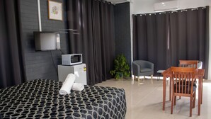A hotel room with a bed, a TV, a microwave, a small table, and a chair. - Wangaratta Motor Inn (Wangaratta)