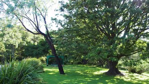 A well-maintained garden with a picnic area, surrounded by lush greenery and trees.