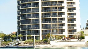Un hotel alto de varios pisos con balcones, situado cerca del agua.