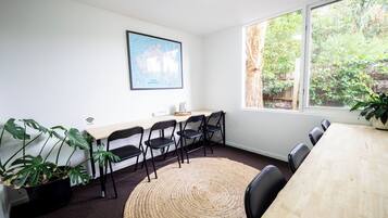 A conference room with a large window, a map on the wall, and a wooden table.