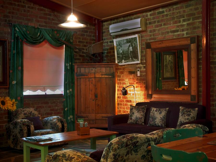 A cozy living room with a brick wall, a wooden bench, a sofa, and a table.