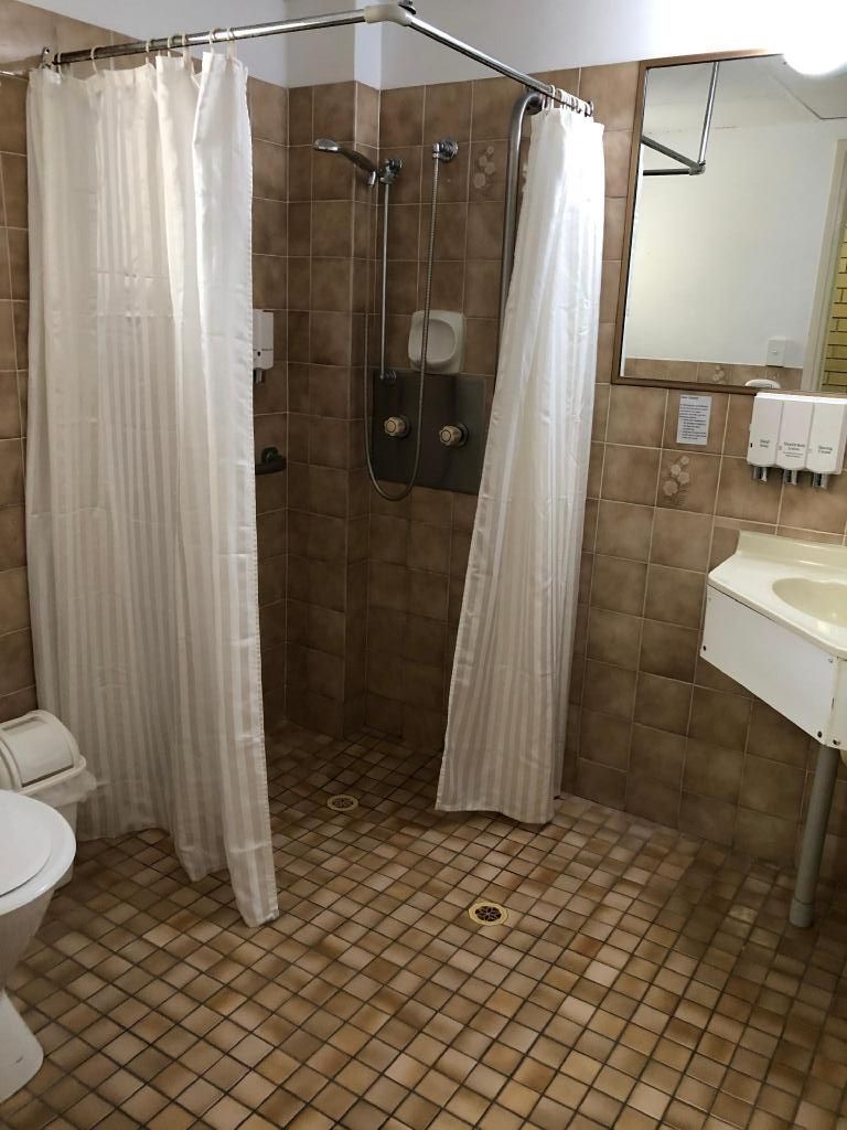 A bathroom with a shower, toilet, and sink.