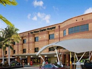 A hospital building with a sign reading 'The Prince Charles Hospital.'