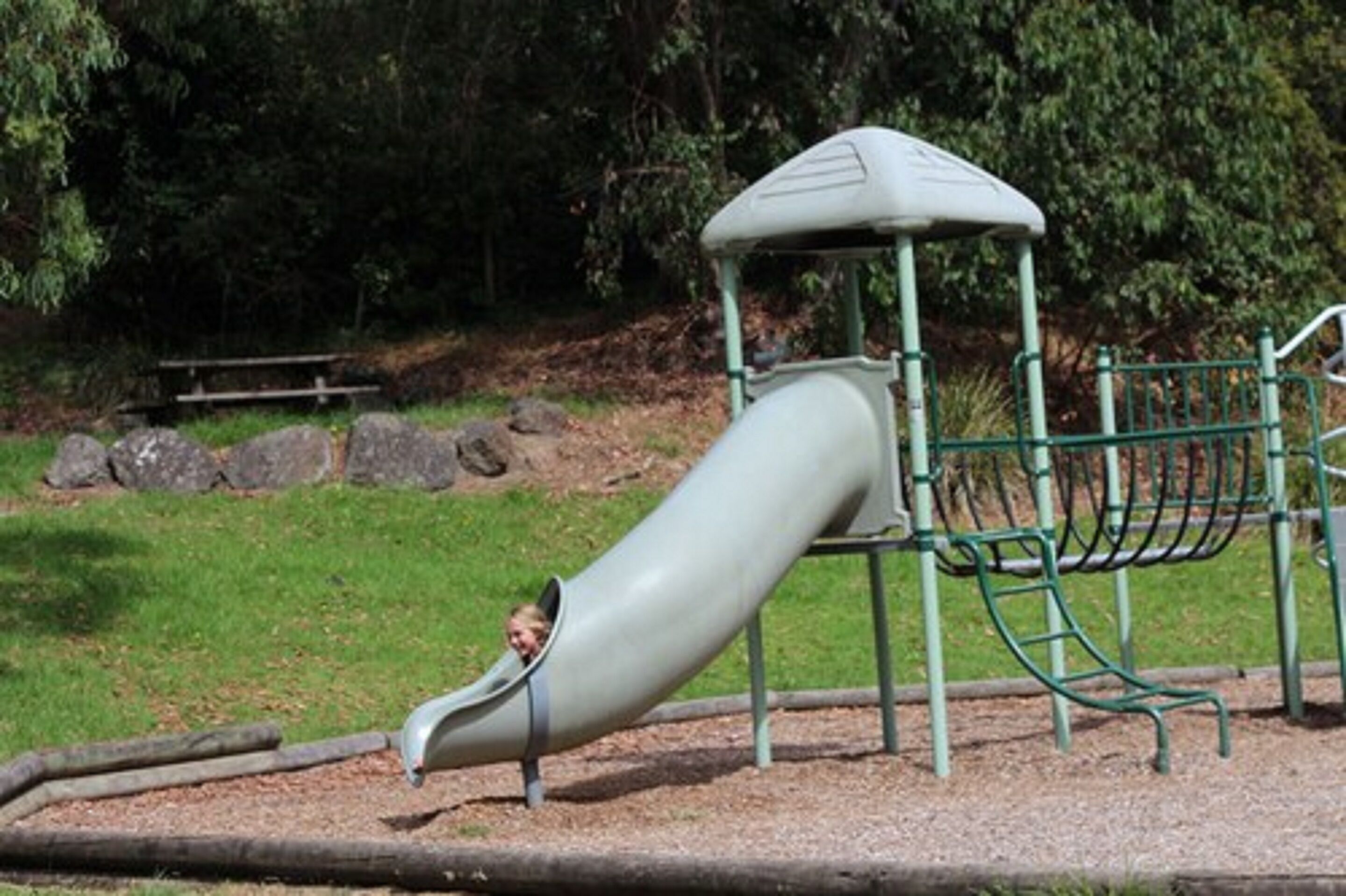 A playground with a slide and climbing structures.
