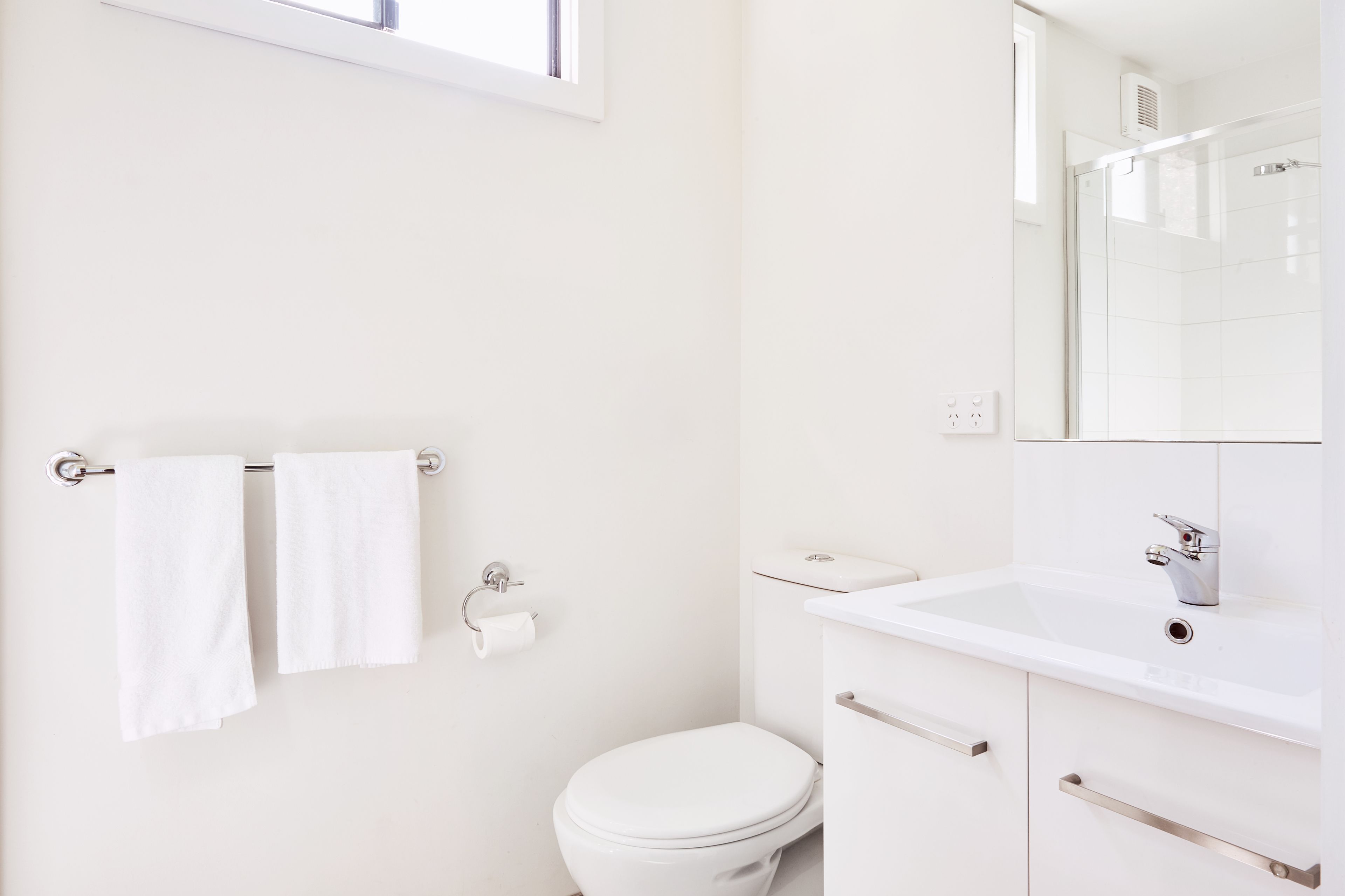 Un bagno moderno con WC, lavabo e cabina doccia in vetro.