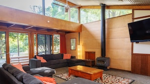 Amplia sala de estar con un gran sofá, una mesa de centro de madera y una chimenea.