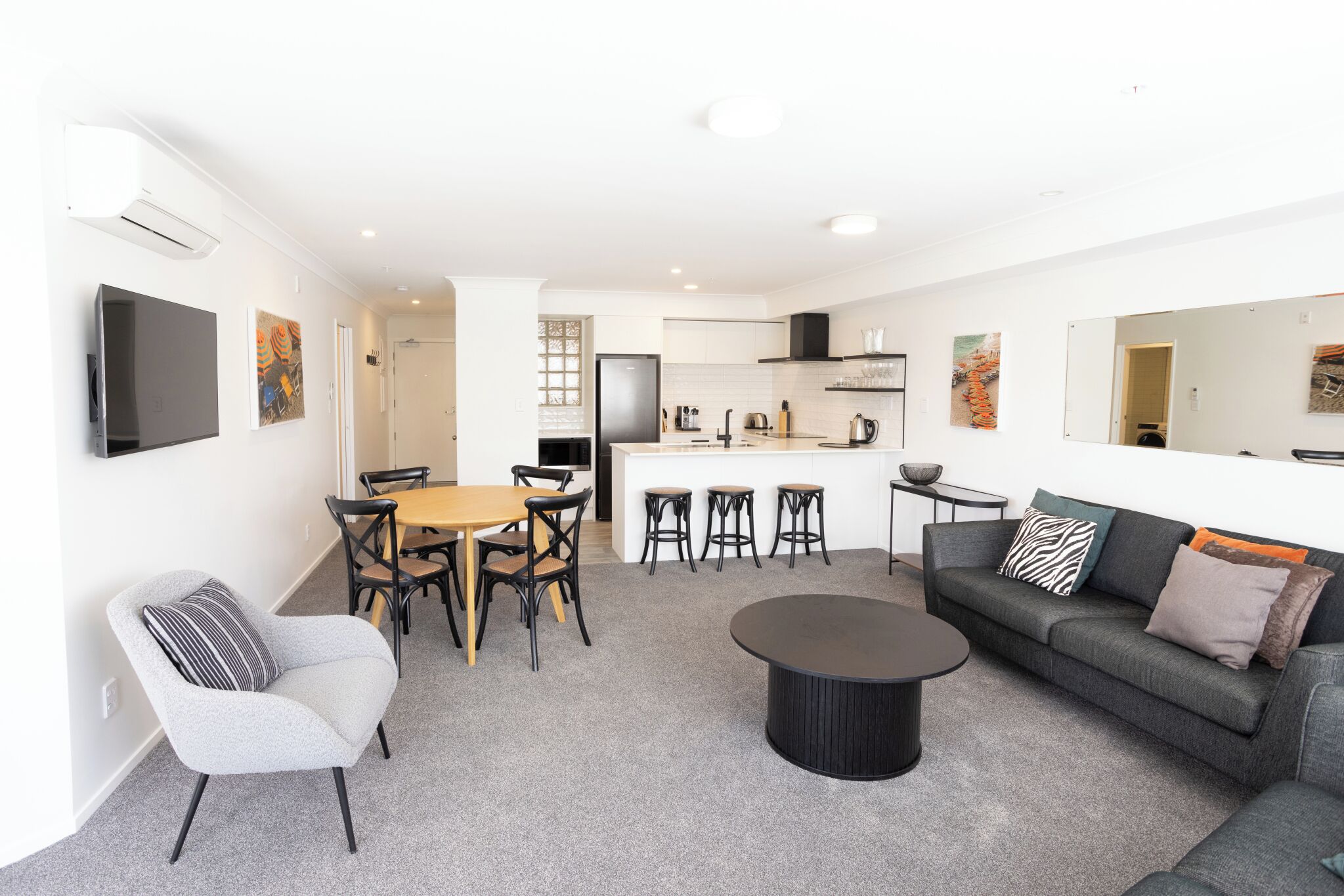 A modern living room with a sofa, coffee table, and dining area.