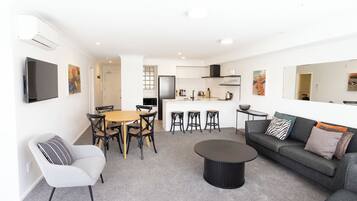 A modern living room with a sofa, coffee table, and dining area.