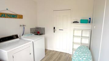 A laundry room with a washing machine, a sink, and a 'Staff Only' door.