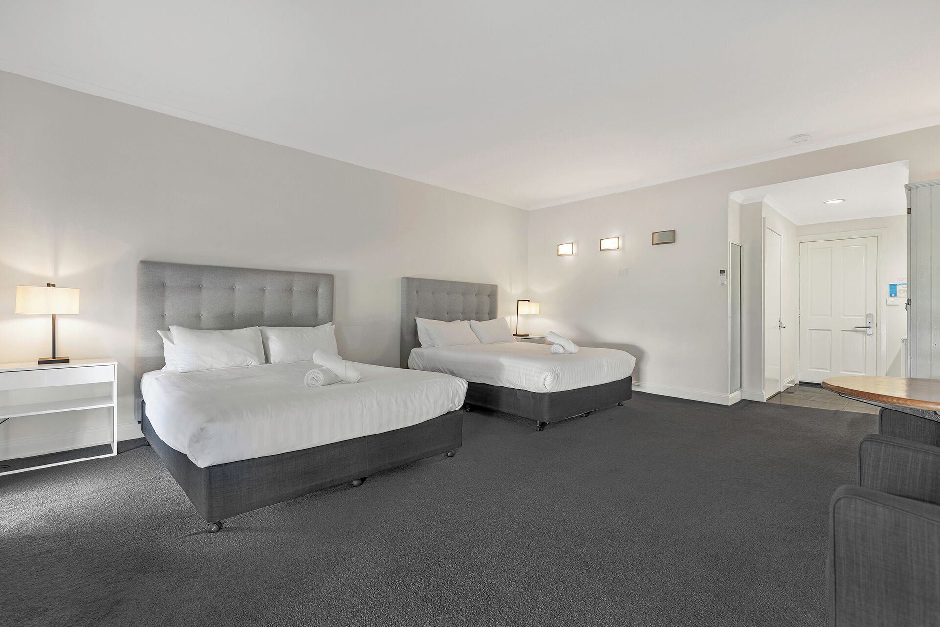 Una habitación de hotel con dos camas, un escritorio y una silla.