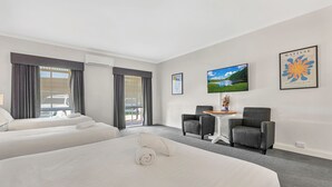 A hotel room with two beds, a TV, and artwork on the walls. - Caledonian Hotel Motel (Echuca)
