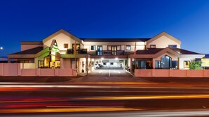 A hotel with a central entrance, multiple balconies, and a parking area. - Drovers Motor Inn (Palmerston North)